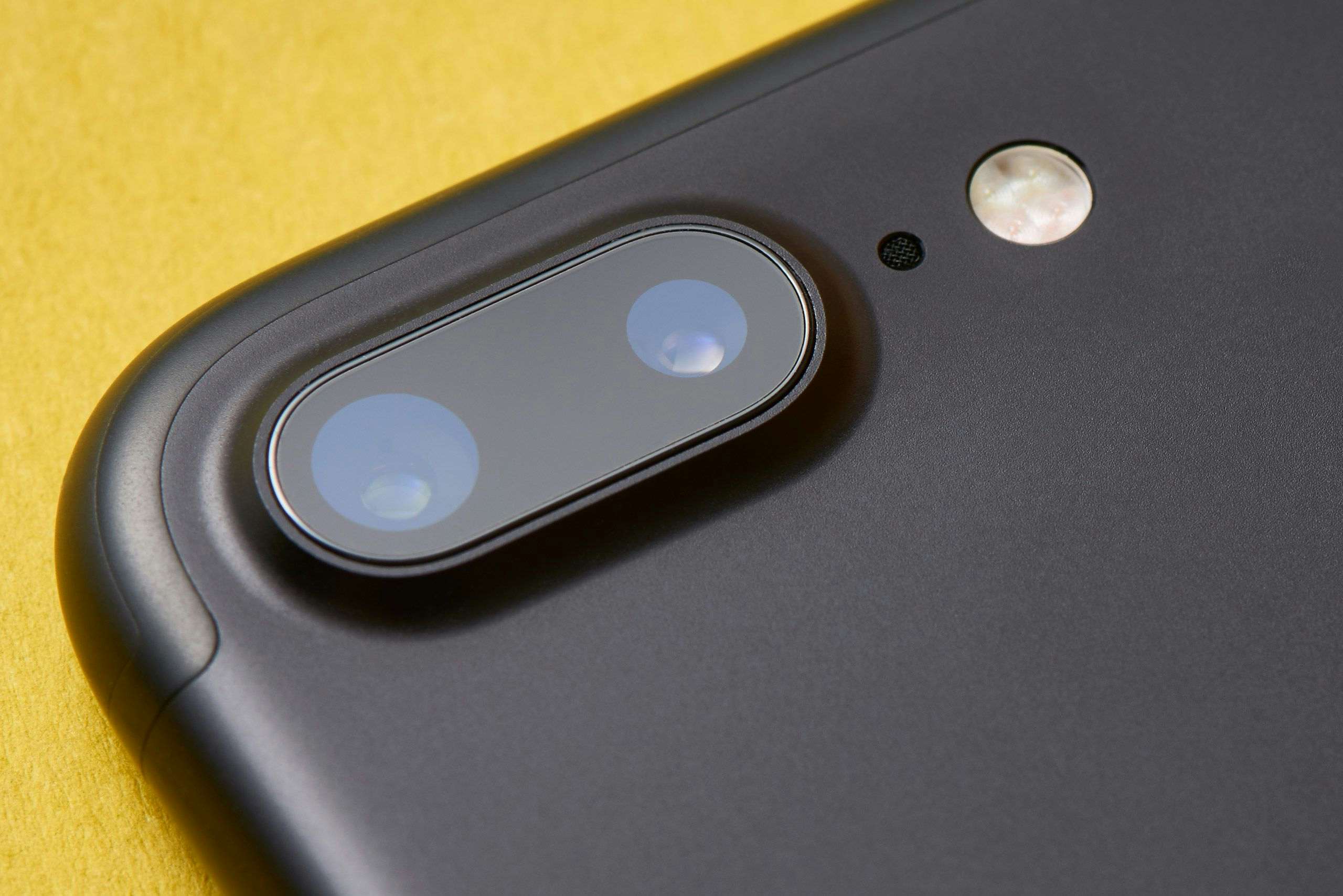 Space gray iPhone 7 Plus dual-camera system and Apple logo close-up. Photography by Xavier Wendling.